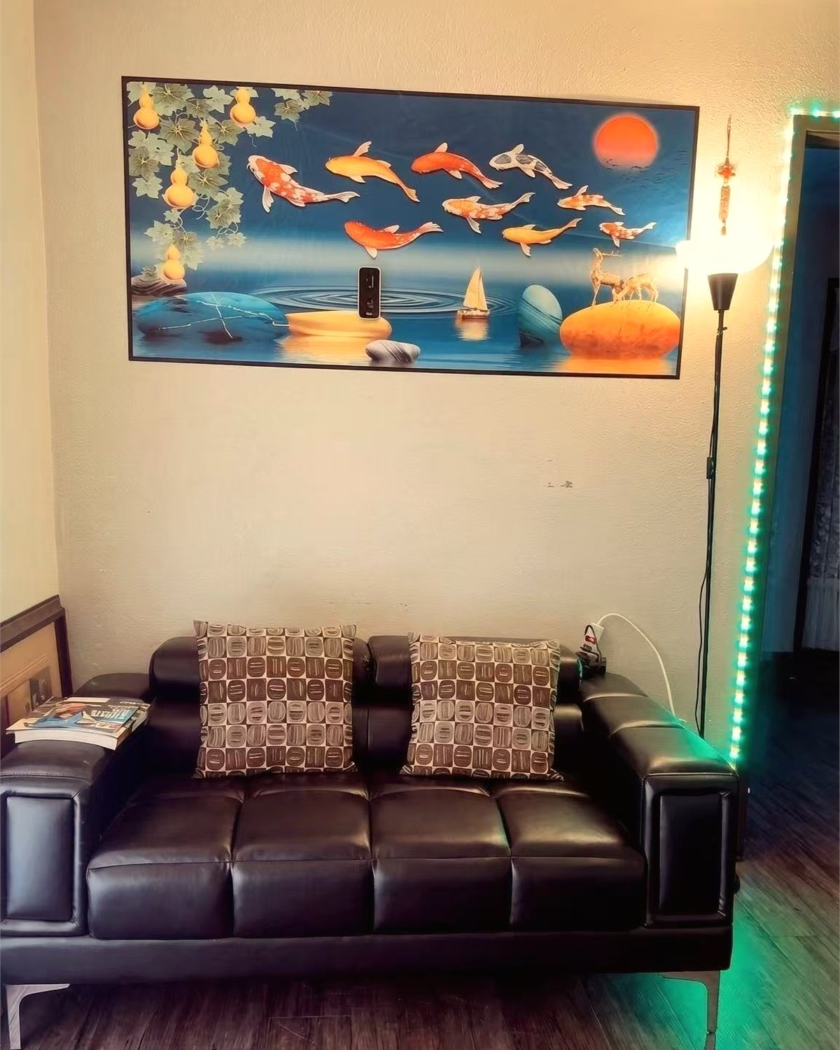 Waiting lounge with dark leather seating and a koi wall artwork