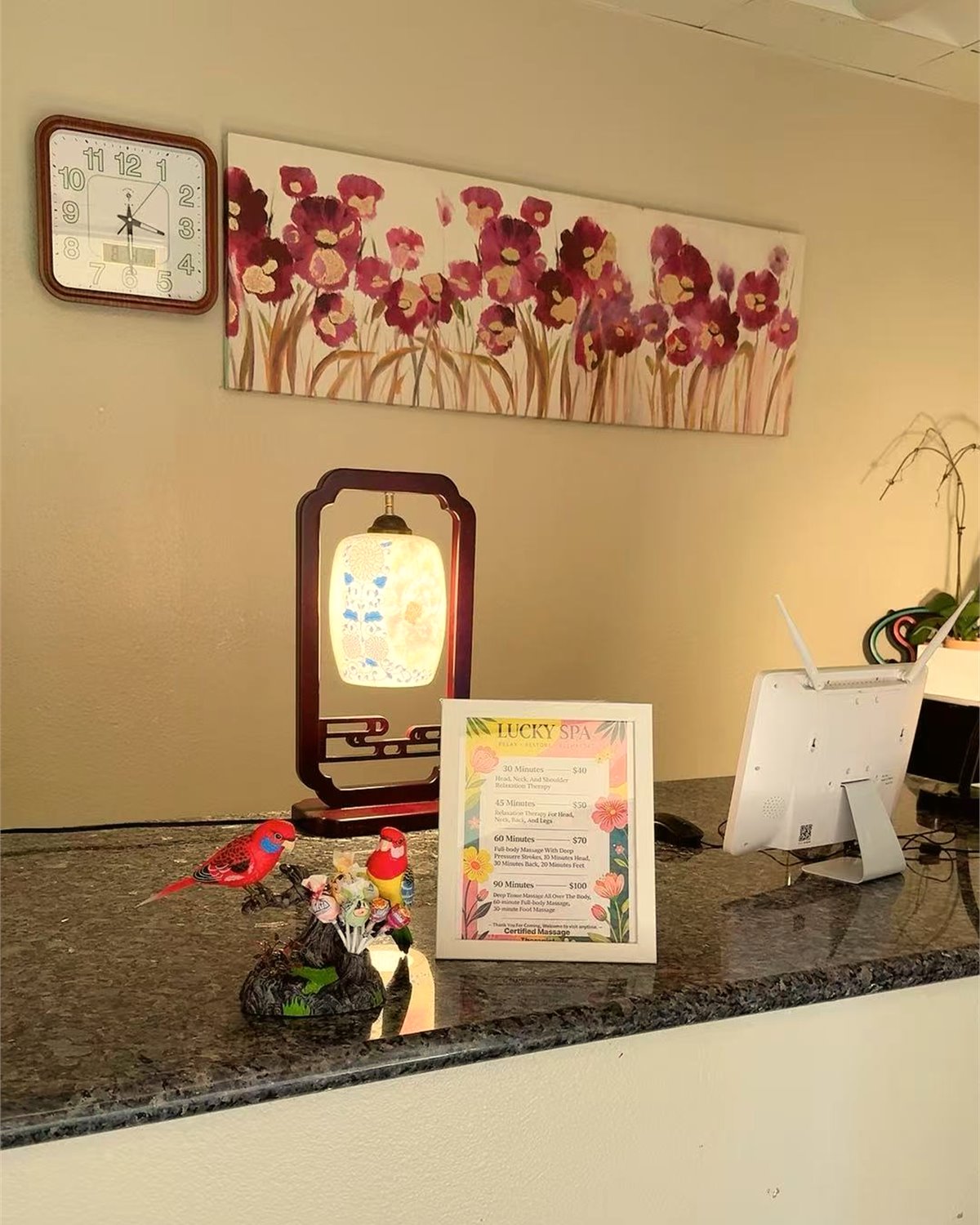 Reception counter with a lamp, small decor, and framed service menu
